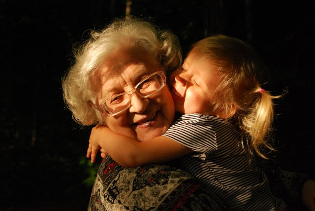 A grandparent teaching a child to stitch